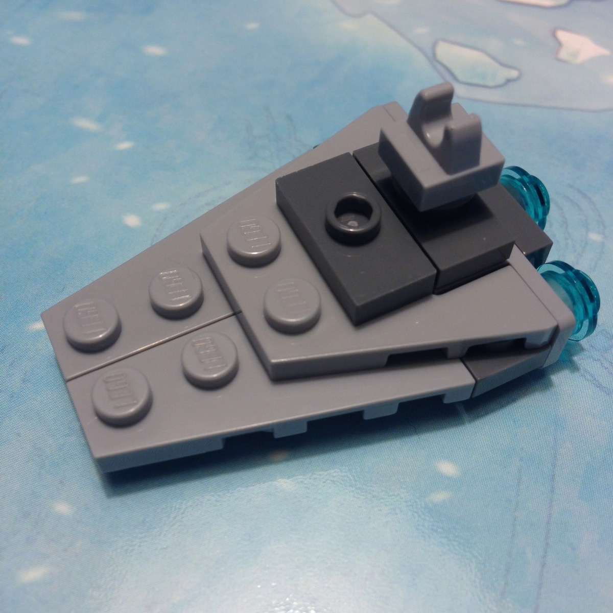 LEGO micro build of an Imperial Star Destroyer mostly in light gray. The 2012 version has three transparent light blue engines at the rear, but the tip is stubby and the bridge tower is not wide enough.