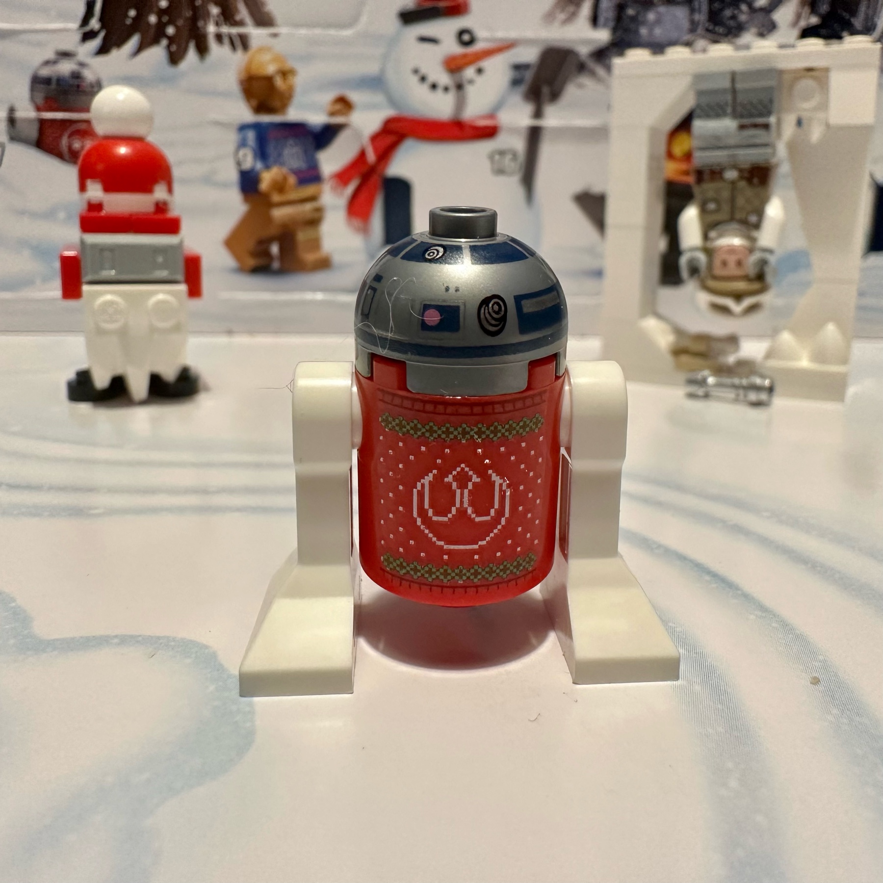 LEGO R2-D2 droid wearing an ugly sweater with a Rebel alliance pattern on the back