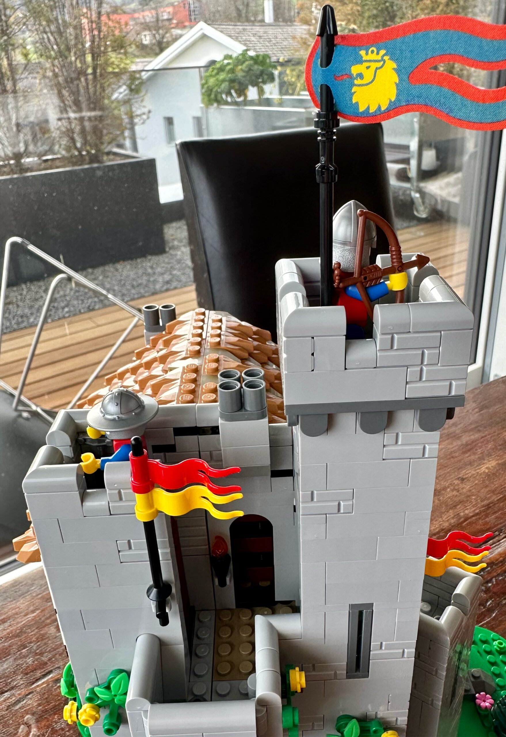 LEGO castle with two stone towers each with a guard atop it and a flying pennant.