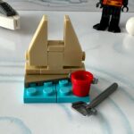 LEGO micro scale build of a sand castle on the water’s edge together with a bucket and a shovel