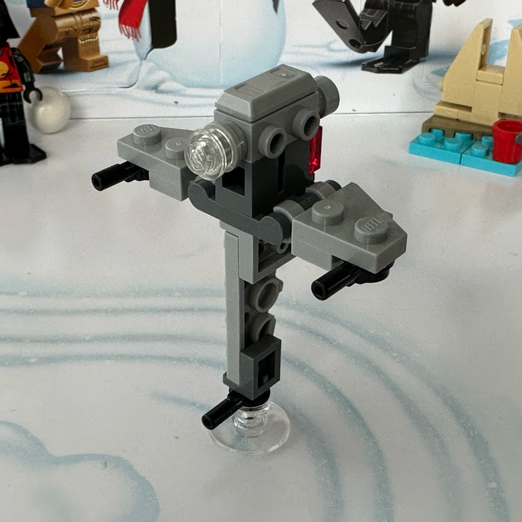 A micro-scale LEGO model of a Star Wars B-Wing fighter posed vertically.