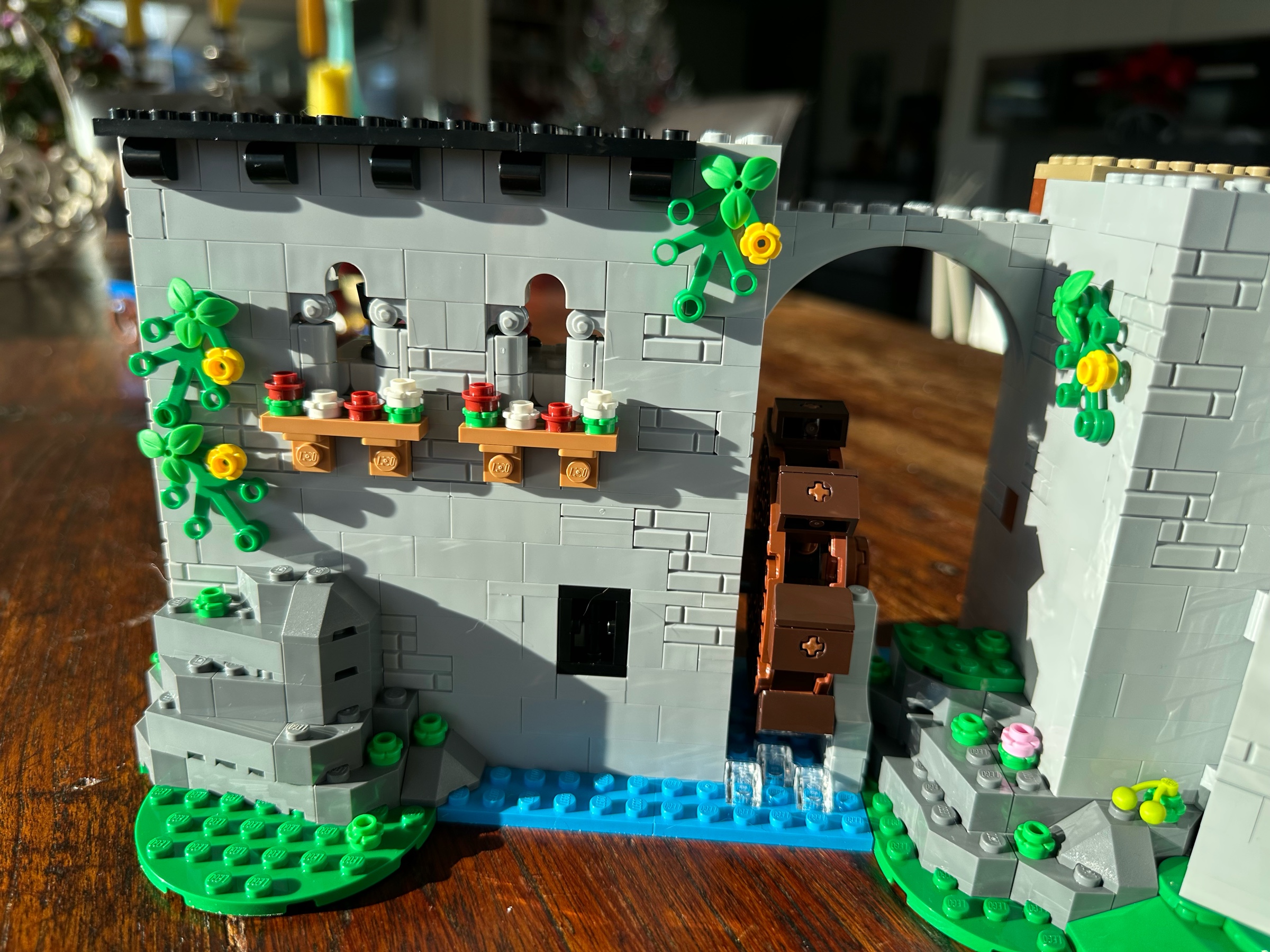 Exterior view of LEGO castle section showing windows with flower boxes set in a vine-covered wall.