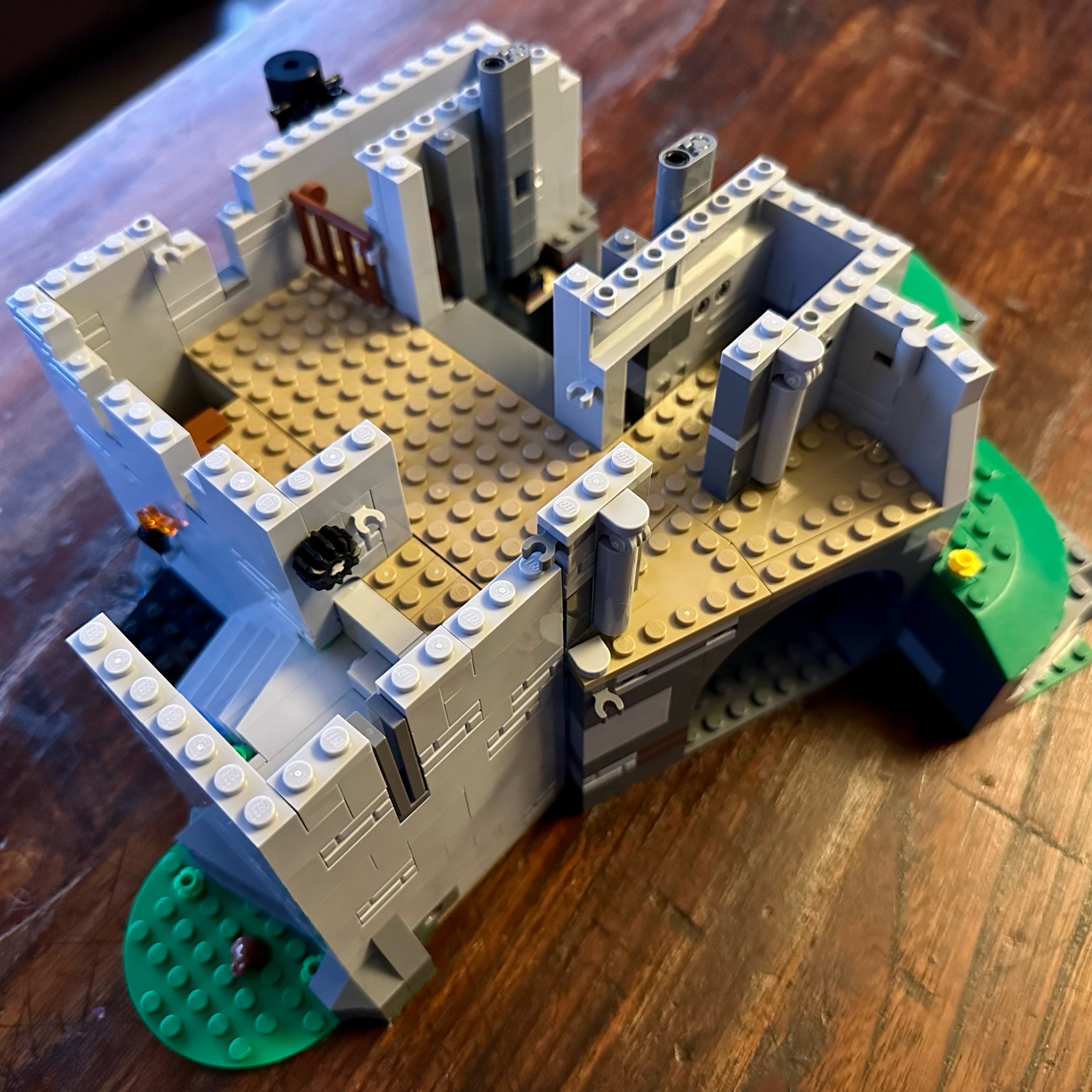 LEGO castle section showing the first floor and partially builtup walls. A low wooden gate forms a stall.