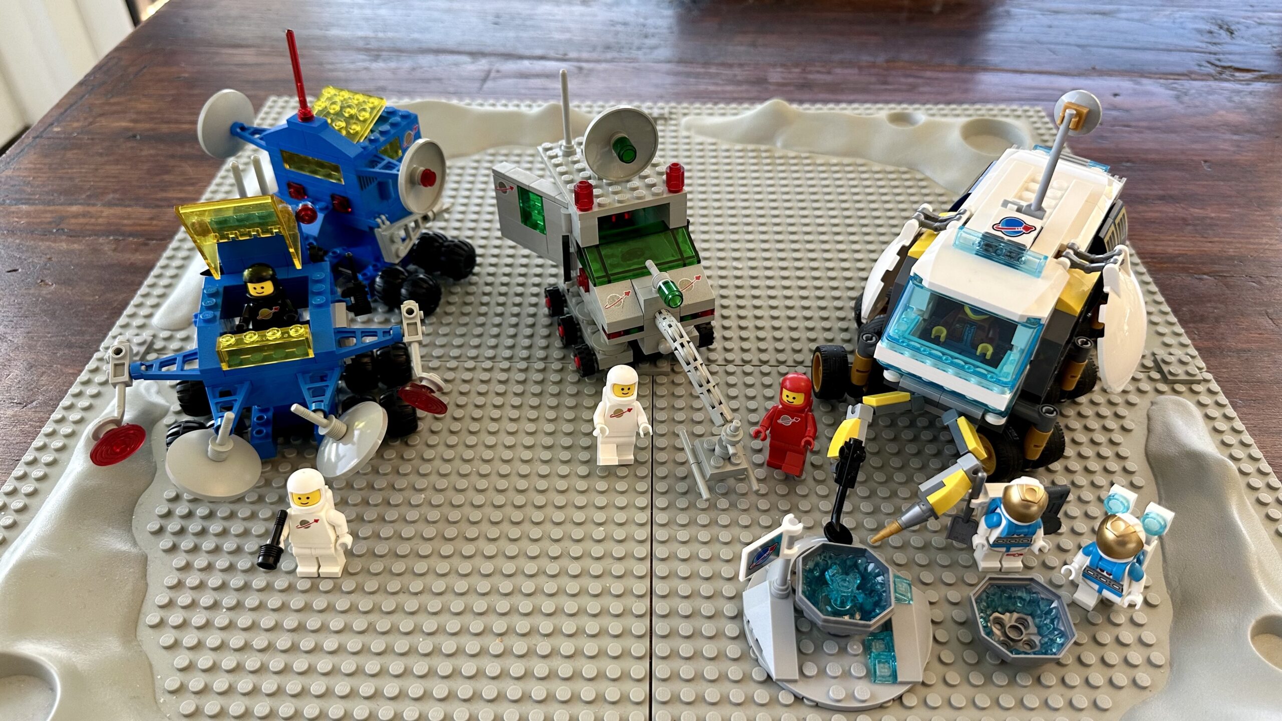 Three LEGO sets of lunar vehicles from 1980, 1984, and 2022.