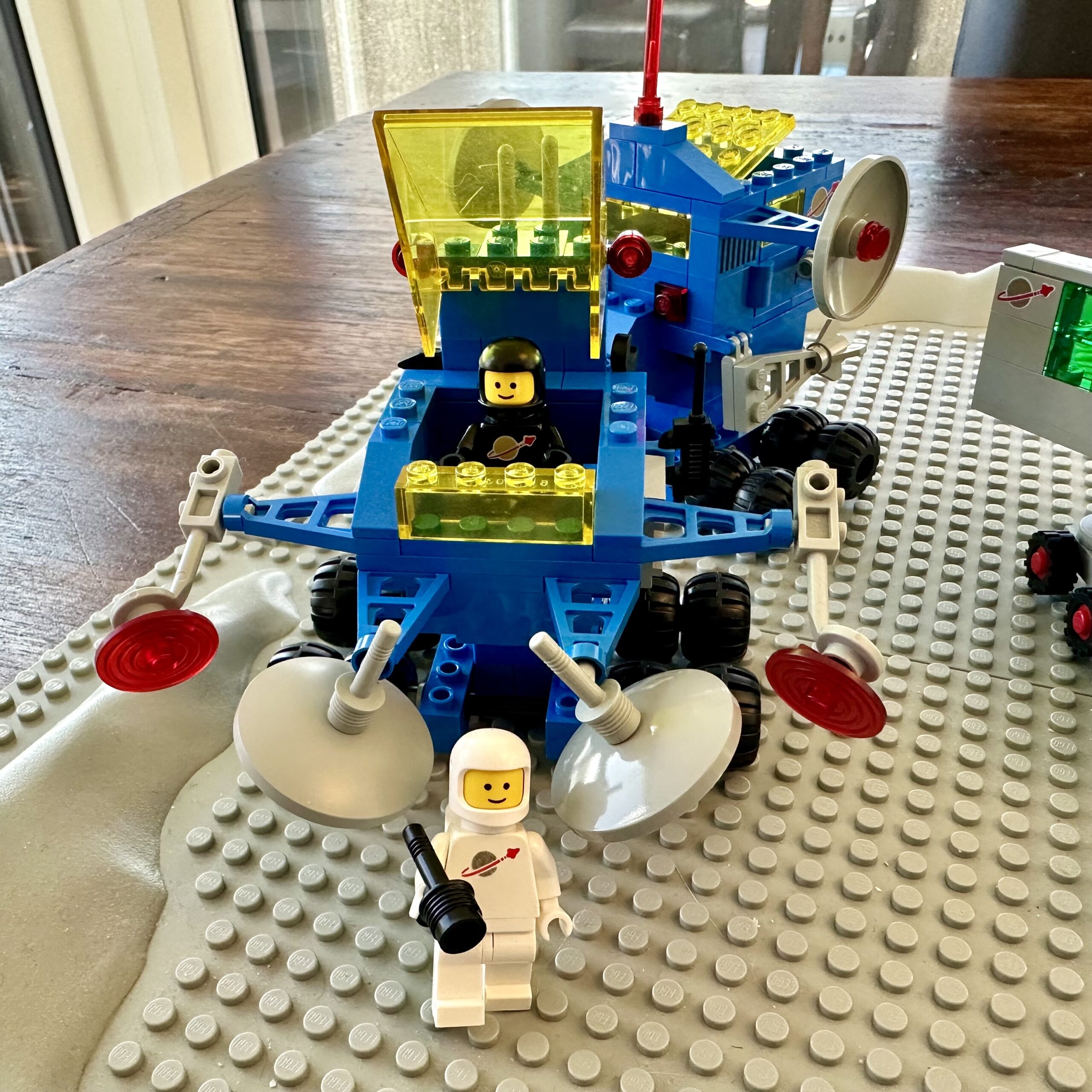 LEGO set 6928: Uranium Search Vehicle from 1984. This blue vehicle has yellow windows and came with white and black suited astronauts.