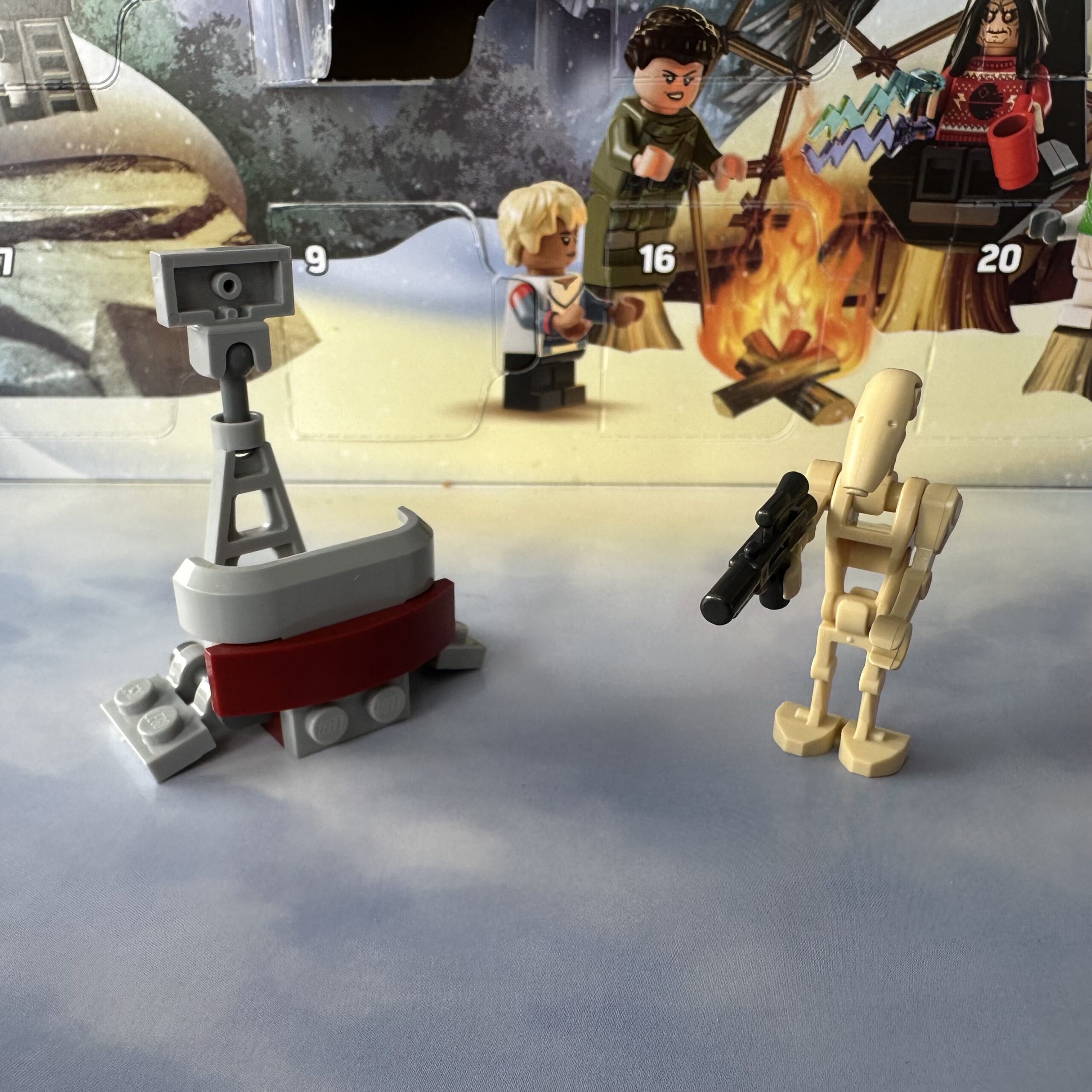 Two LEGO micro-builds. A nondescript amalgamation of mostly gray bricks on the left and a battle droid minifigure holding a blaster on the right