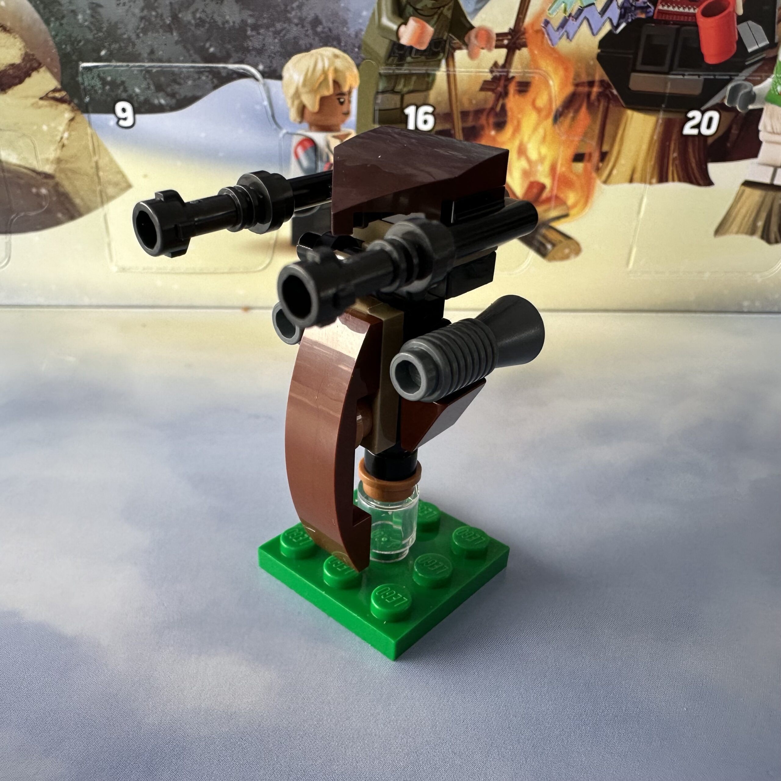 LEGO micro-build of a Star Wars Clone Wars era battle droid speeder. It's mostly brown and black and hovers above a small square of grass.