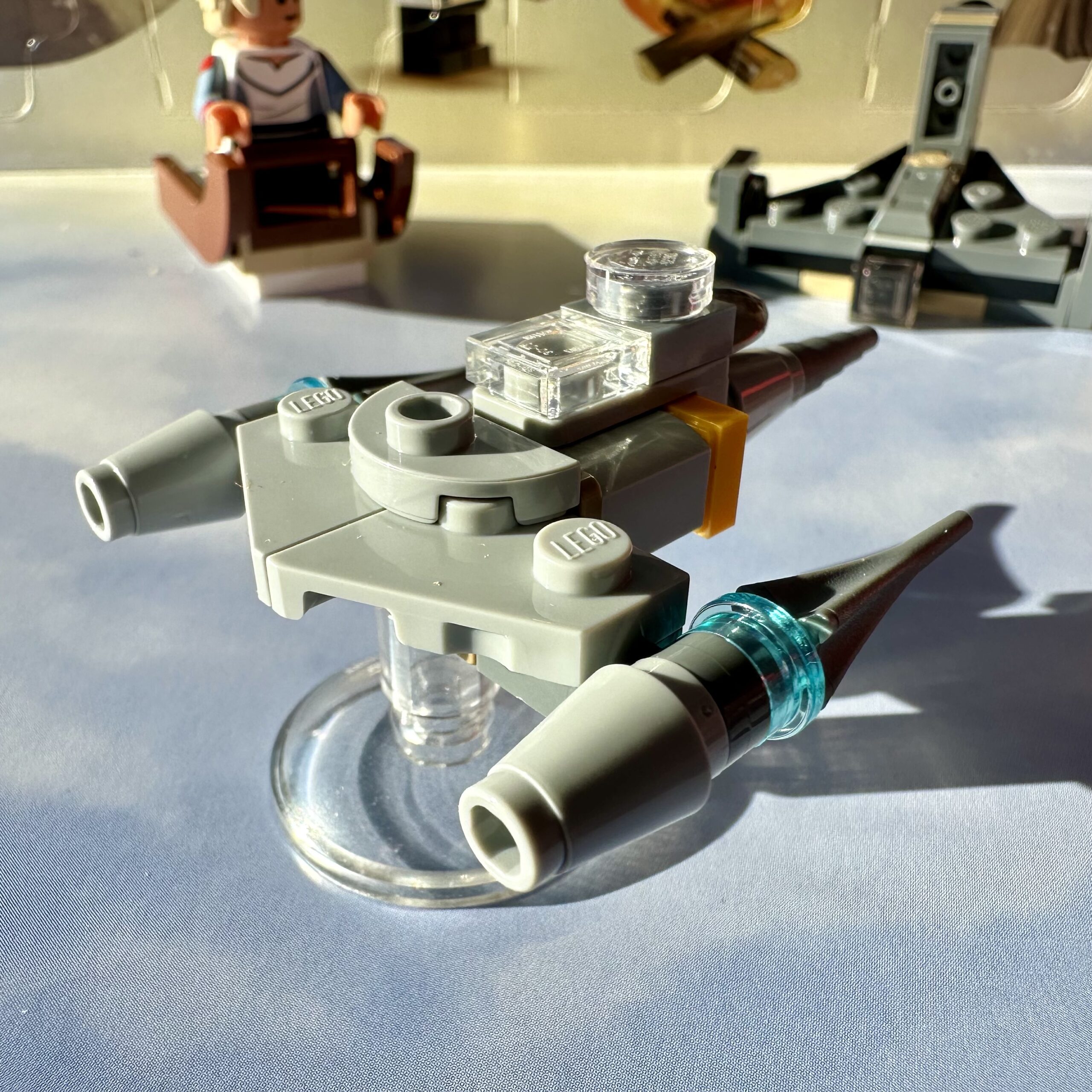 Mini LEGO build of the Mandalorian's N-1 Starfighter. It's mostly made of light gray parts and has a sleek shape.