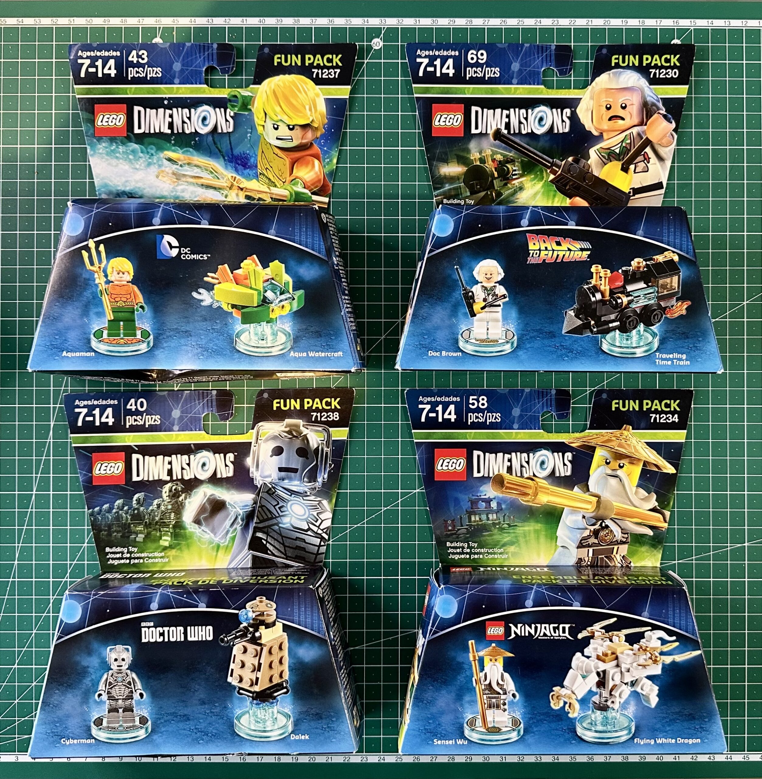 Four different boxed sets of LEGO Dimensions Fun Packs: Aquaman, Back to the Future, Doctor Who, and Ninjago's Master Wu.