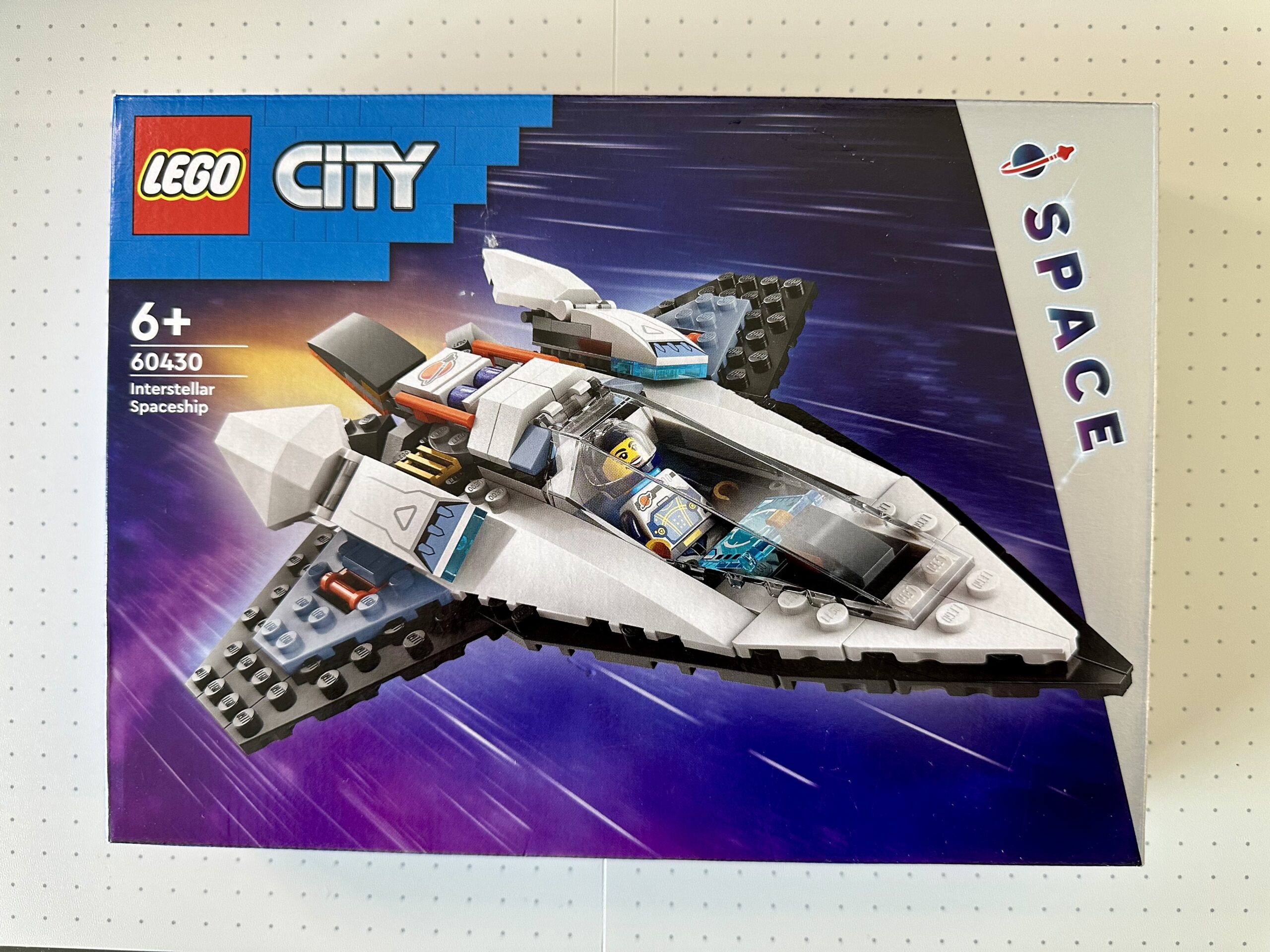 Box for LEGO City Space set 60430 Interstellar Spaceship. Box depicts a sleek white and black spaceship piloted by an astronaut.